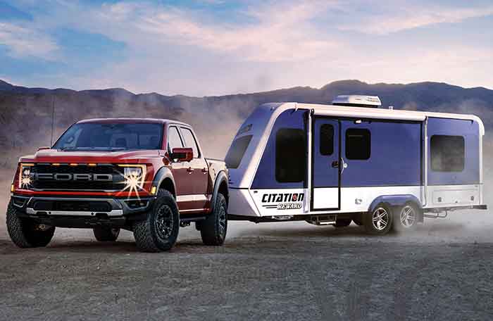 A truck and a trailer parked at the mountain view scenery