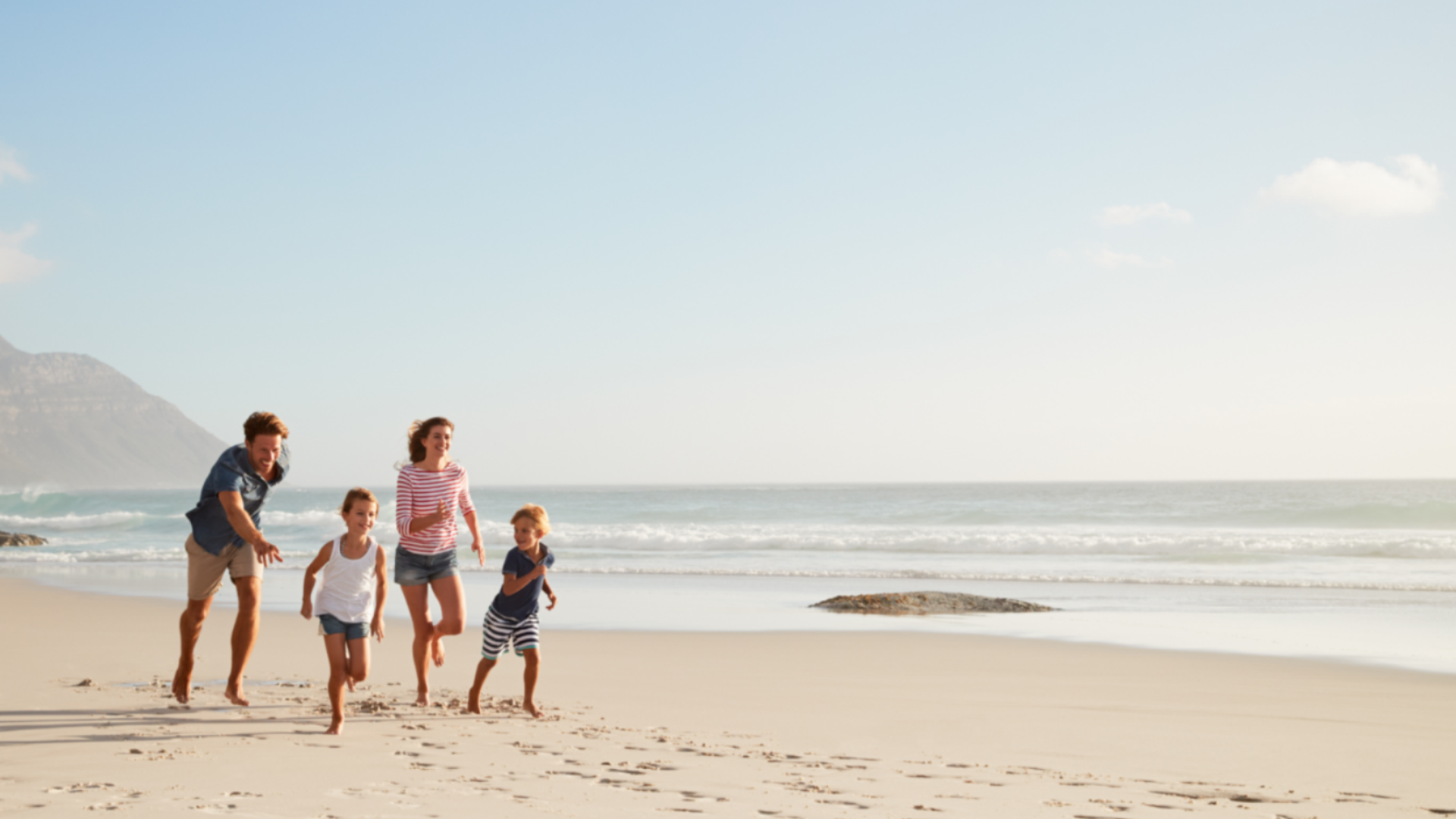 A portrait of the family running on the beach 