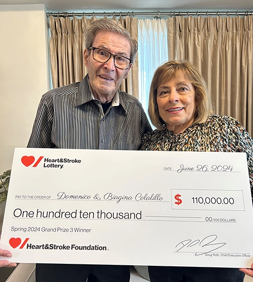 Domenico Colalillo and his wife hold a cheque from Heart & Stroke Lottery for $110,000