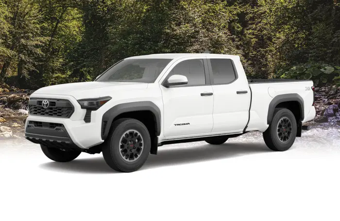 A Toyota Tacoma truck parked in front of a picturesque countryside backdrop.