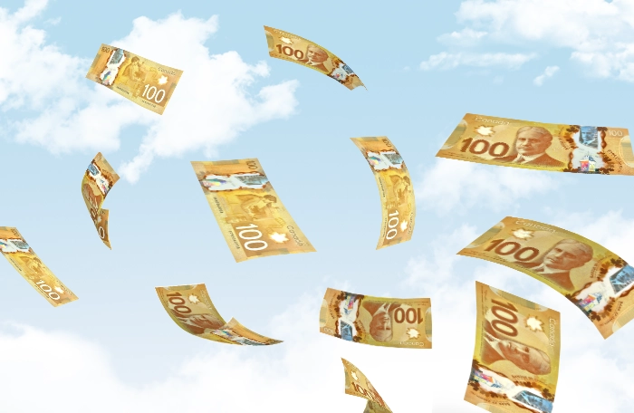 Canadian $100 bills flying in the sky.