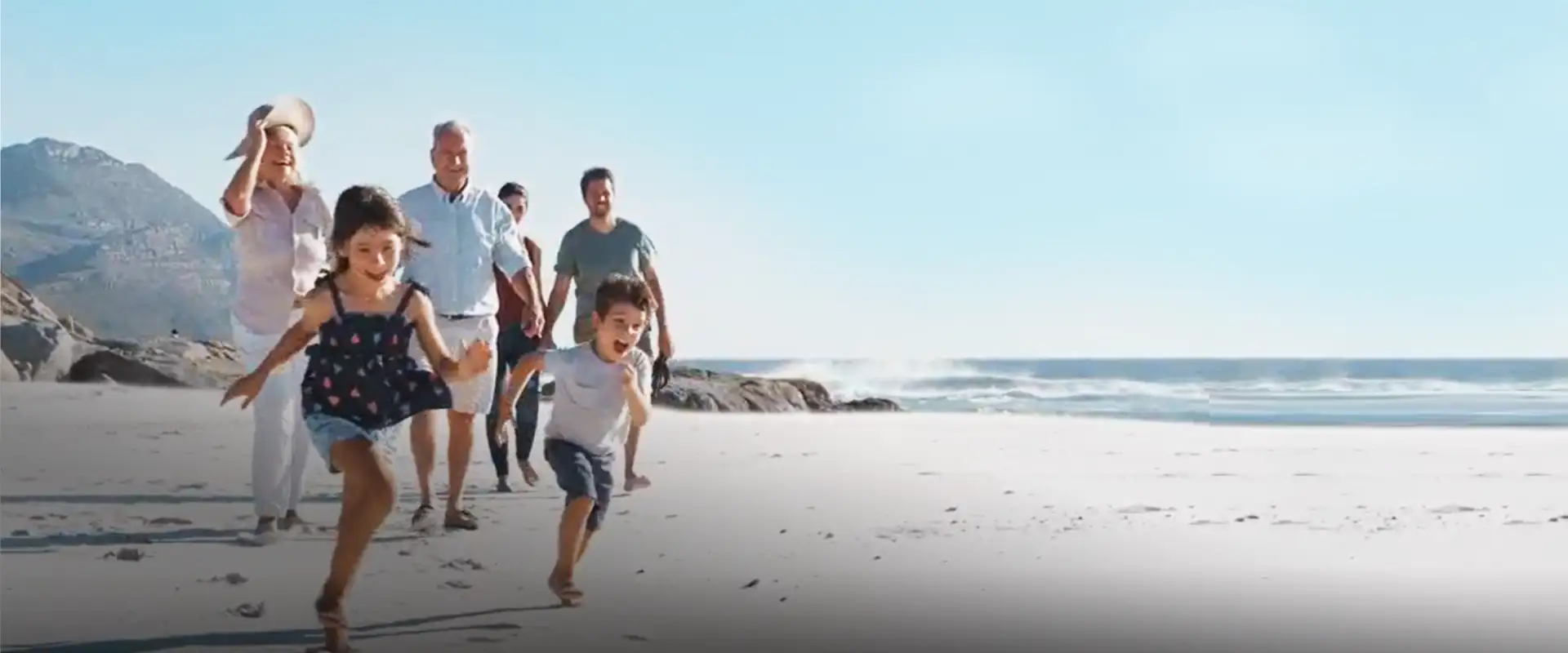 Happy 3-generation family enjoying their time walking on a beach. 