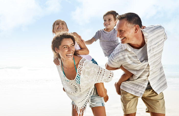 A family walking together on the beach.