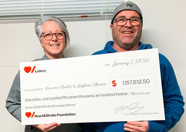 Man and woman holding large novelty cheque 