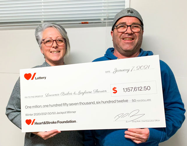 Man and woman holding large novelty cheque 