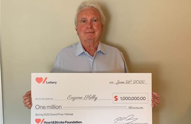 Heart & Stroke Spring 2022 Lottery Grand Prize winner Eugene Kelly holding his cheque for $1 million.