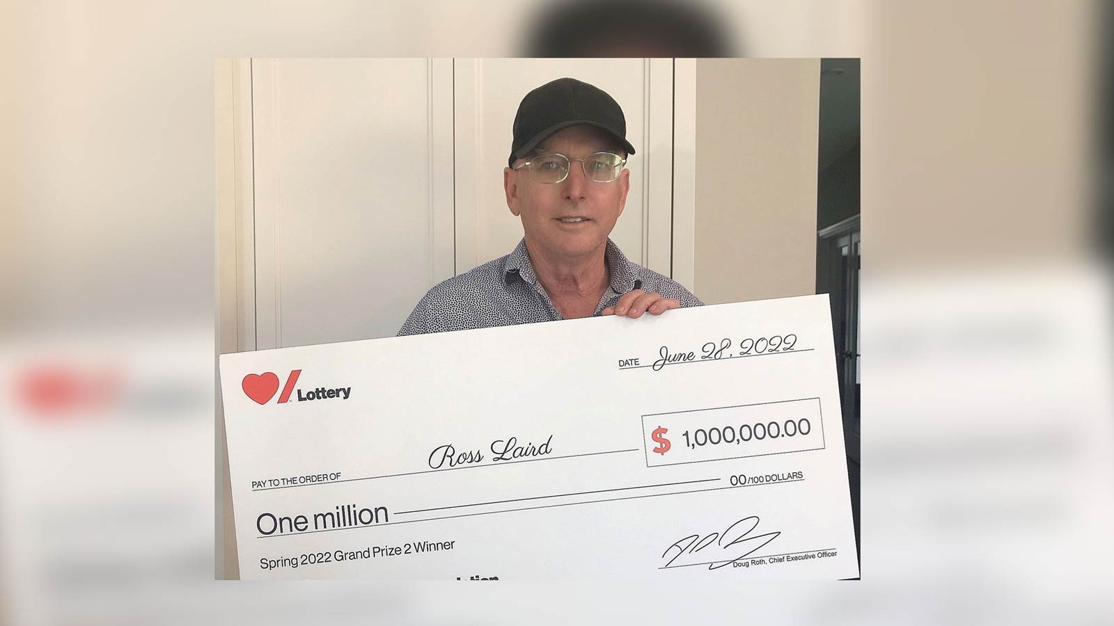 Heart & Stroke Spring 2022 Lottery Grand Prize winner Ross Laird holding his cheque for $1 million.