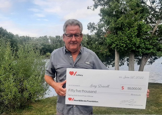 Heart & Stroke Spring 2022 Lottery Grand Prize #4 winner Greg Driscoll holding his cheque for $55,000