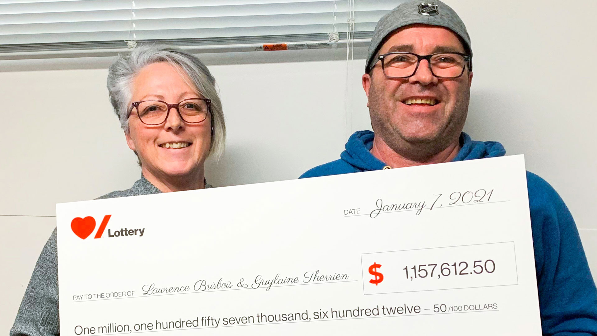 Man and woman holding large novelty cheque 