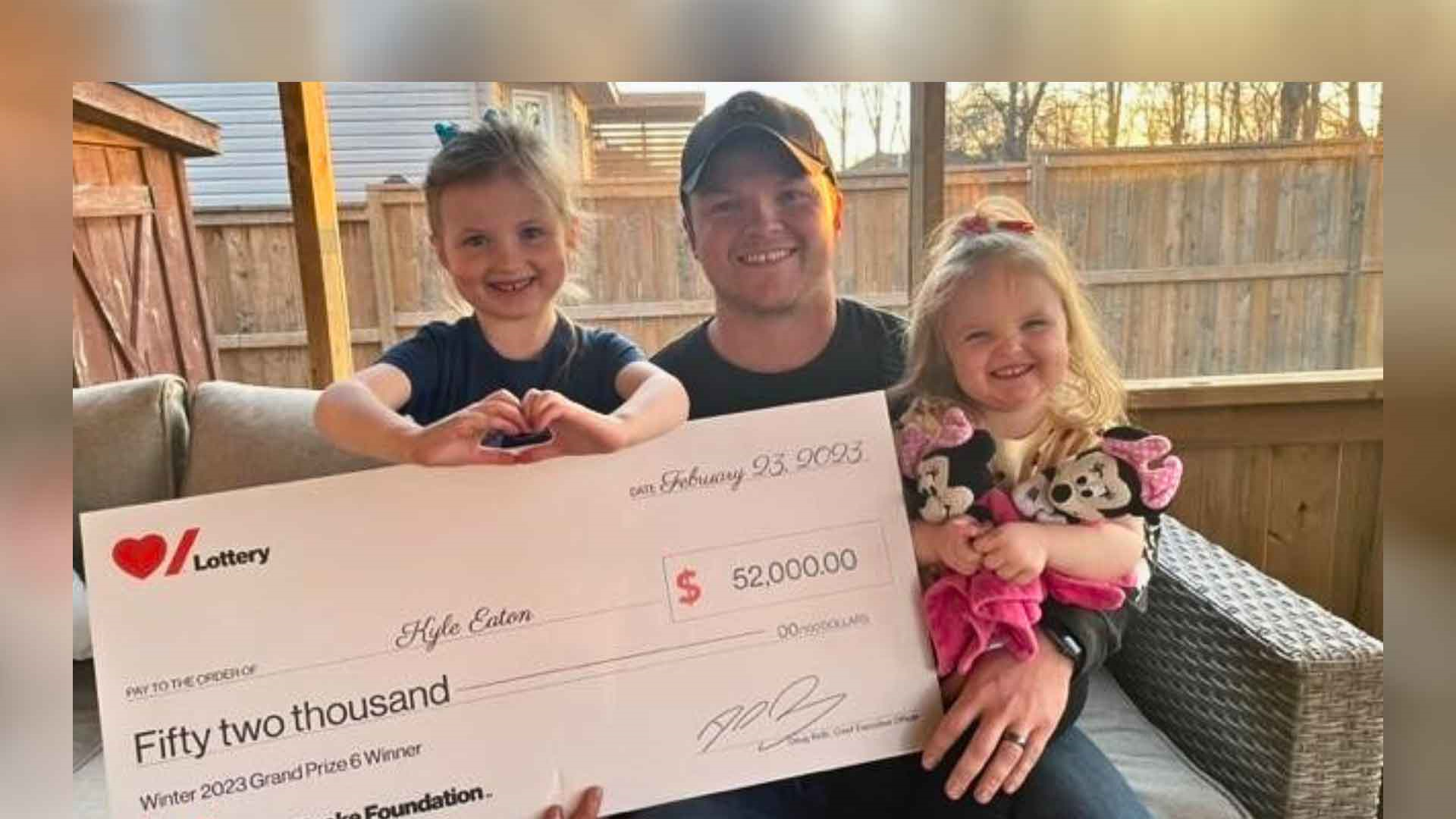 Kyle Eaton and his kids hold their winning cheque for $52,000
