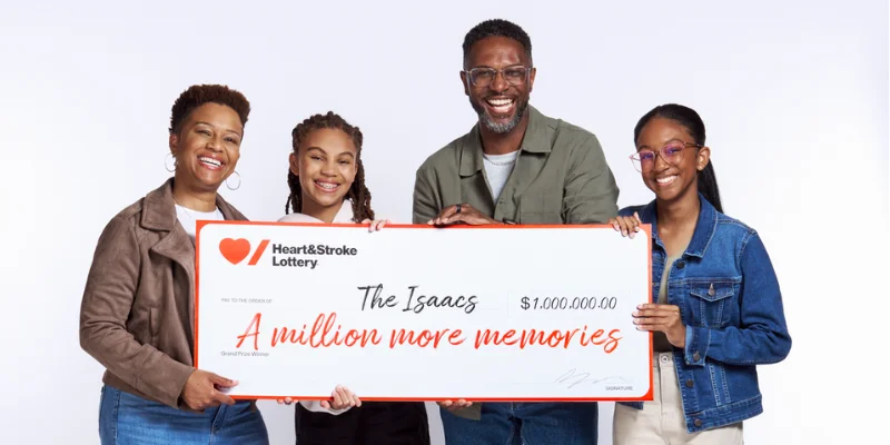 Stroke survivor Katherine Isaac with her family, holding a "cheque" made out to "The Isaacs" for "A million more memories"