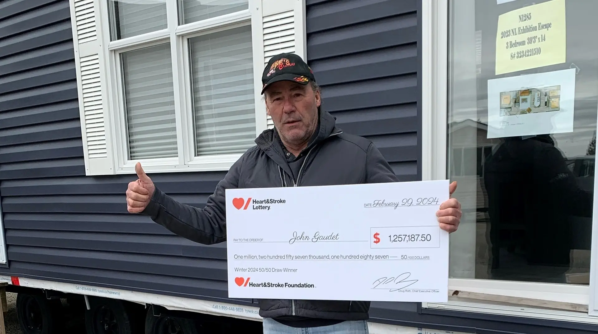 John Gaudet holds a giant cheque for $1,257,187.50