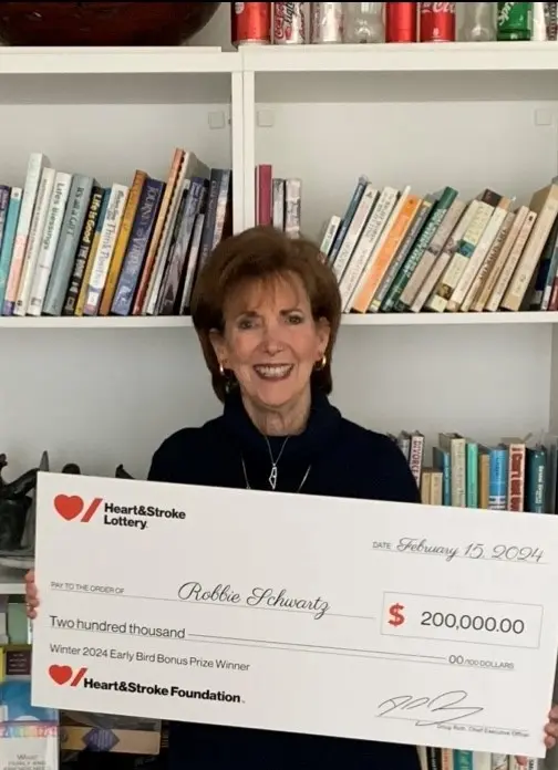 Robbie Schwartz holding a giant cheque for $200,000.