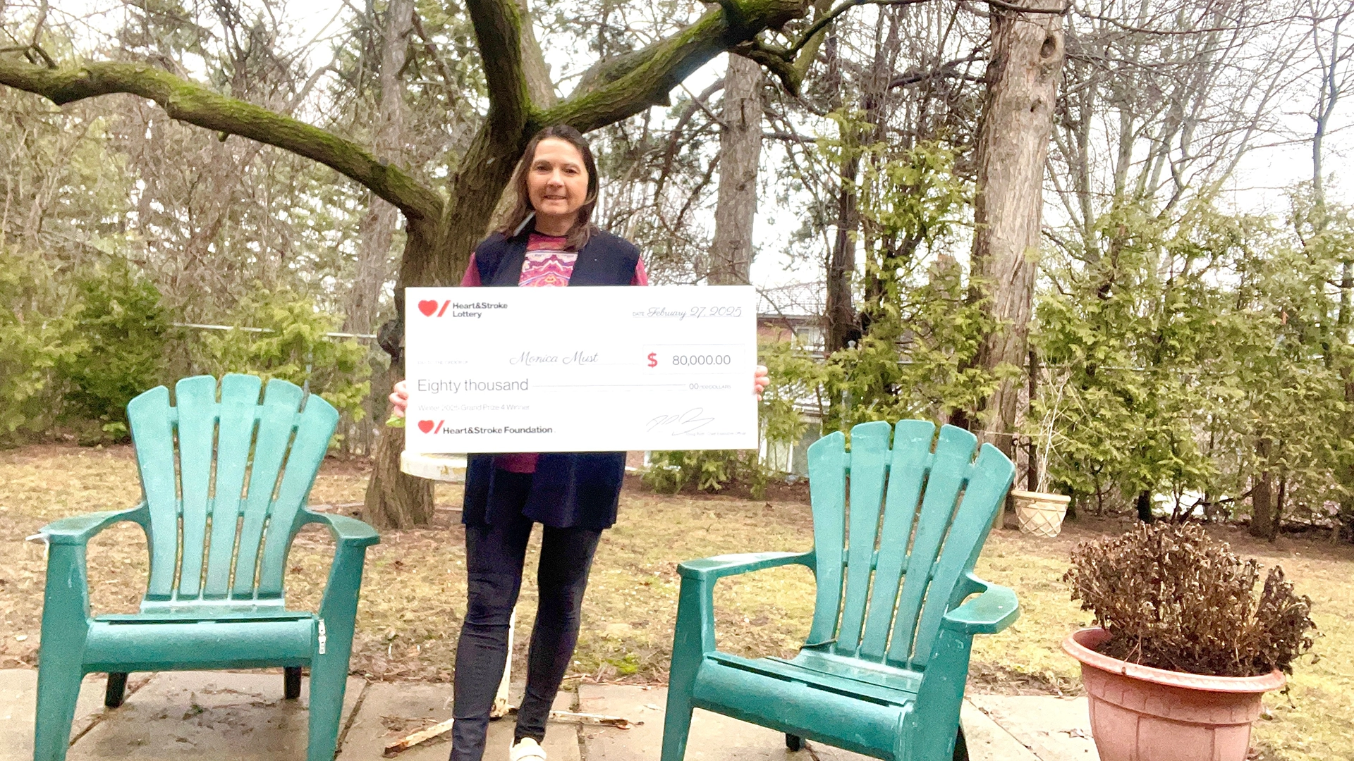 Winter 2025 Grand Prize #4 winner Monica Must holding a novelty cheque for her winning.