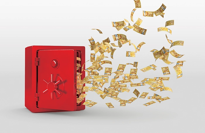 Bank notes flying out of a red safe