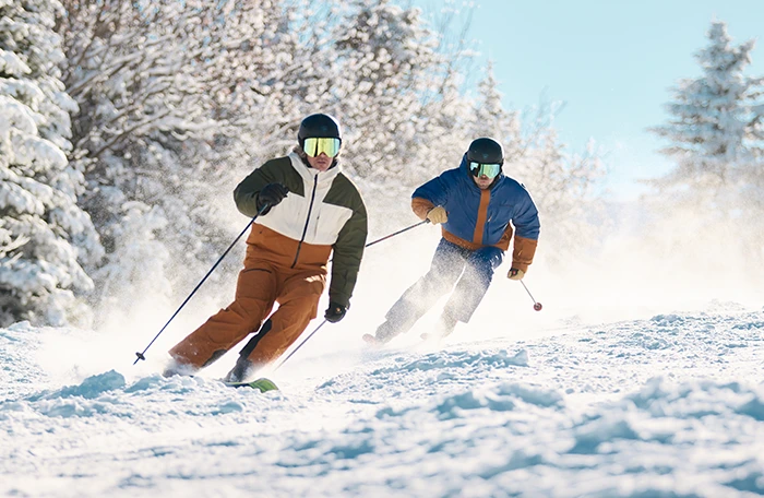 Image of 2 people skiing down a slope
