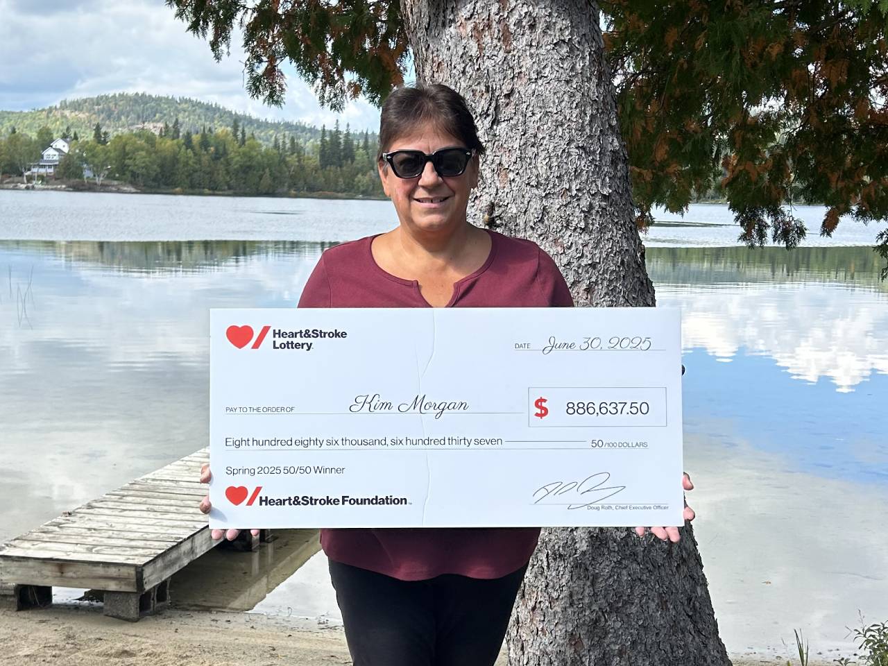 Spring 2025 Lottery – 50/50 Prize Winner Kim Morgan holding a novelty cheque for her winning. 